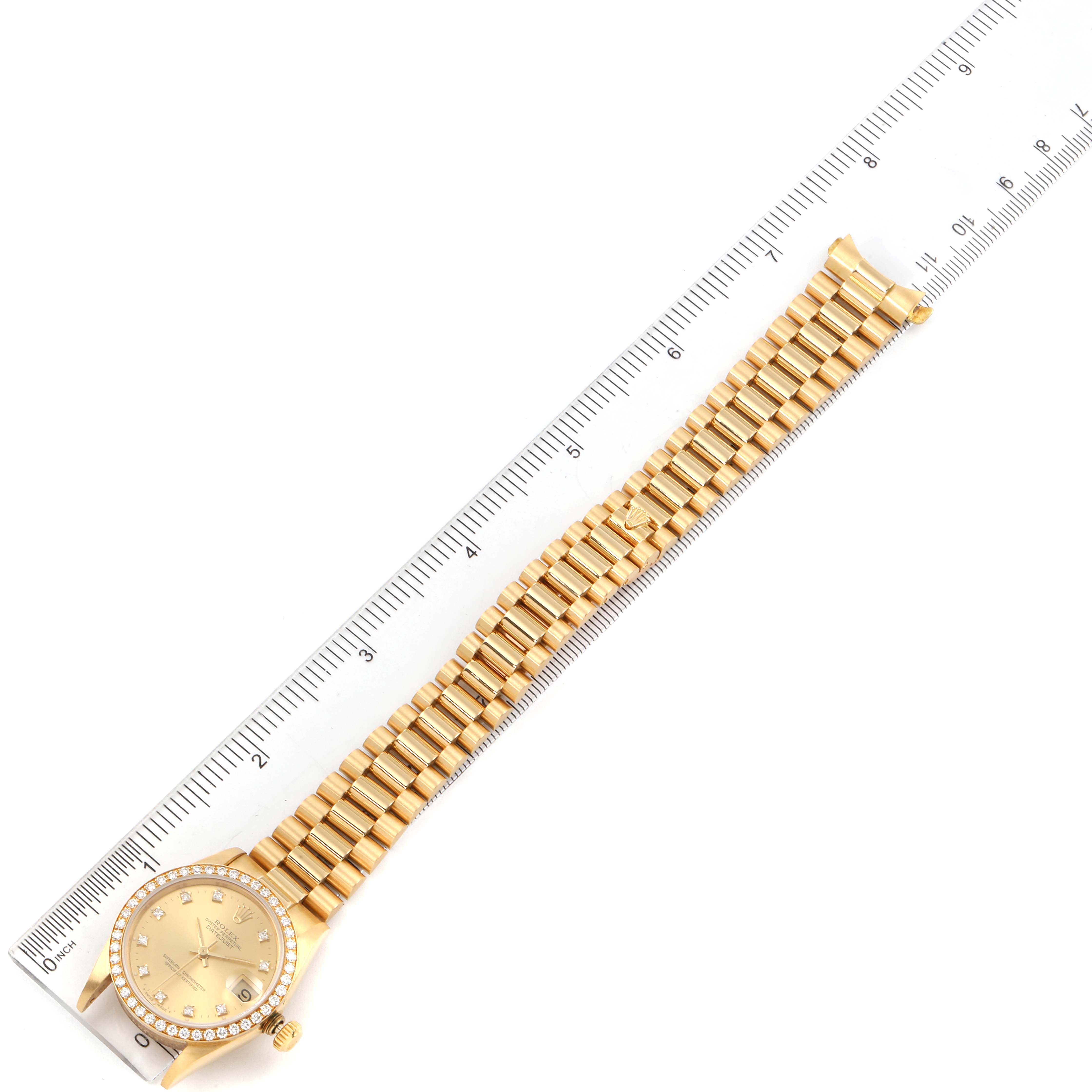 The image shows a gold Rolex President 68288 Women's White Gold Champagne Dial 68288 Women's White Gold Champagne Dial model watch laid flat alongside a ruler, displaying the face and full length of the band.