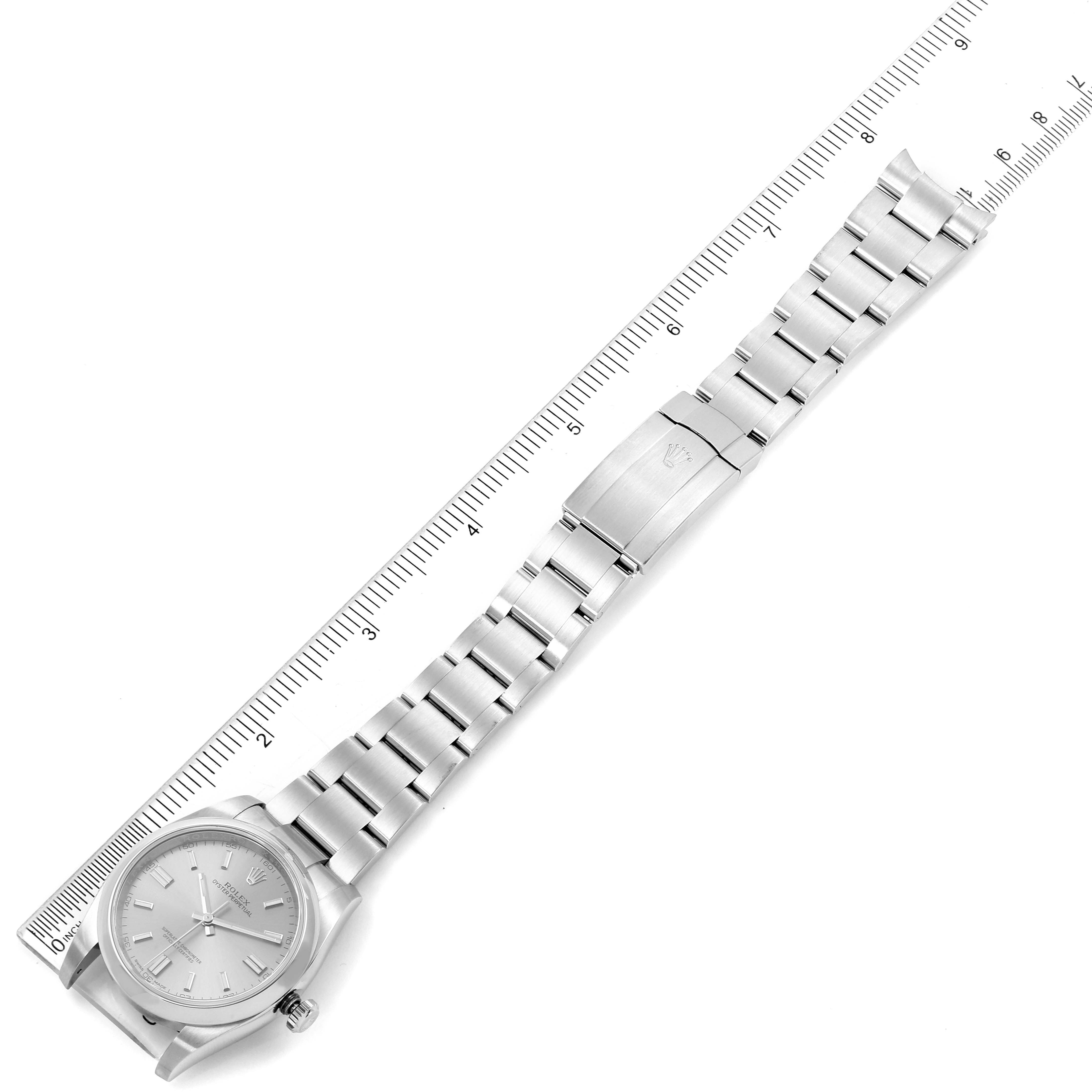 The image shows the full length and clasp of a Rolex Oyster Perpetual 116000 Men's Stainless Steel Grey Dial 116000 Men's Stainless Steel Grey Dial watch placed alongside a ruler for size reference.
