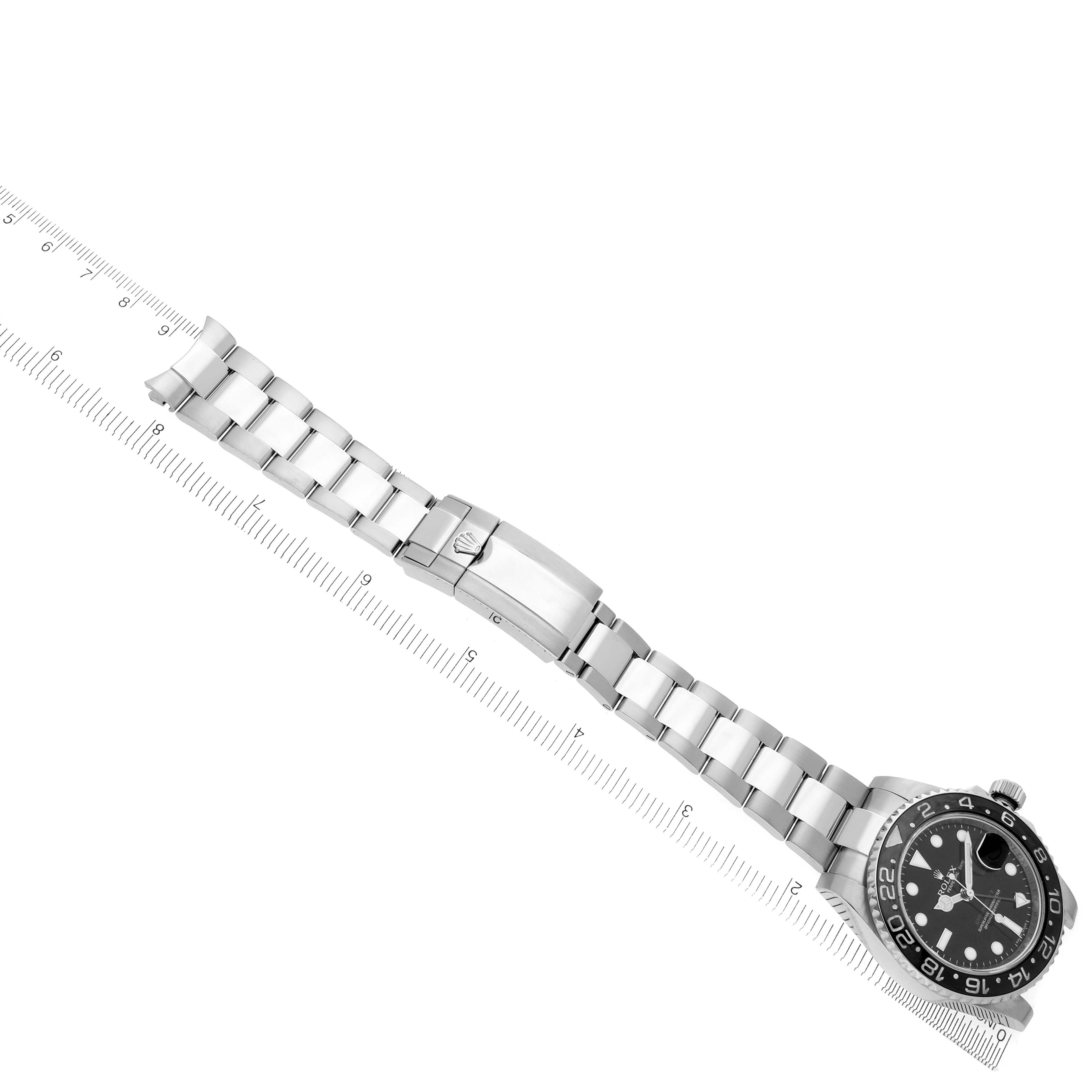 The Rolex GMT-Master 116710LN Men's Stainless Steel Black Dial 116710LN Men's Stainless Steel Black Dial watch is shown from a top view, displaying the bezel, dial, bracelet, and clasp alongside a ruler.