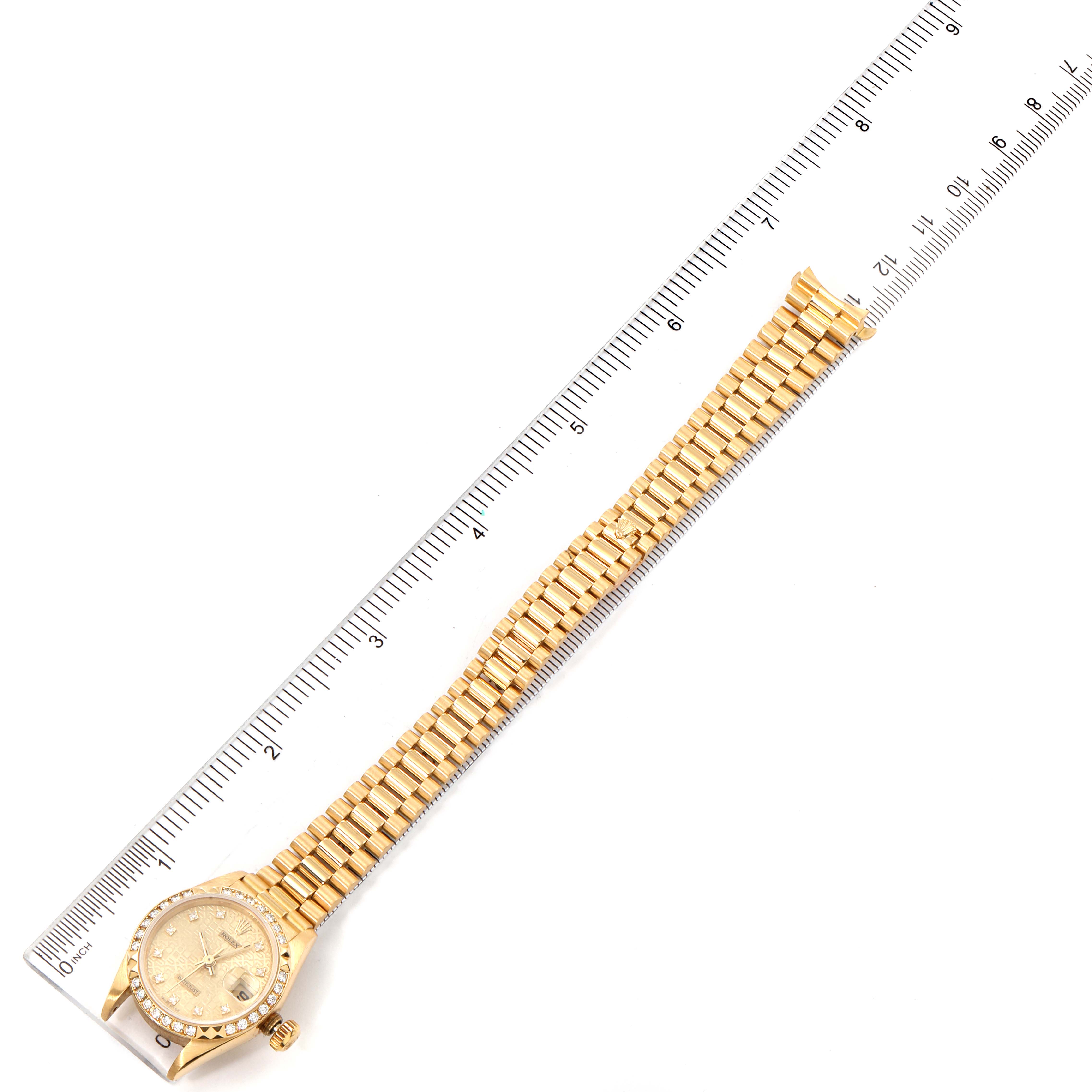 This image shows a Rolex President 69268 Women's Yellow Gold Champagne Dial 69268 Women's Yellow Gold Champagne Dial model watch laid flat next to a ruler, showcasing the face and bracelet.