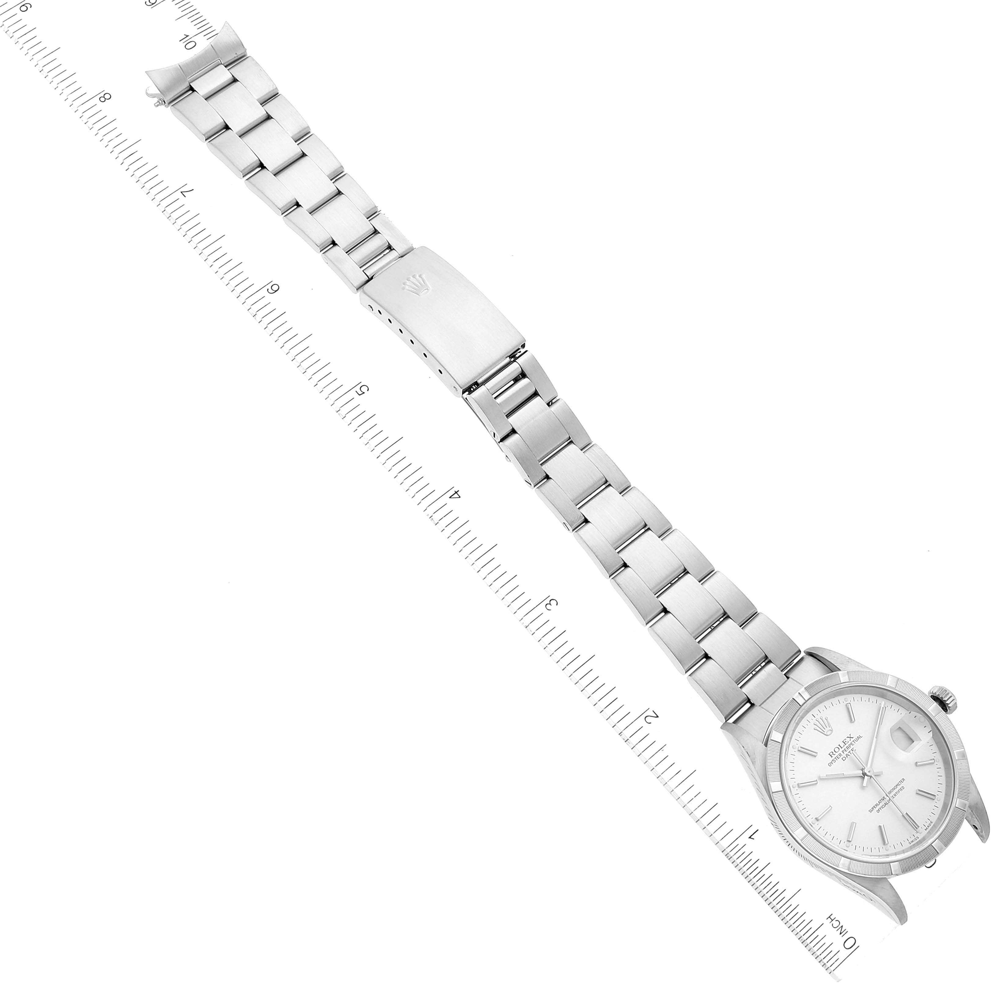 The image shows an overhead view of a Rolex Date 15210 Men's Stainless Steel Silver Dial 15210 Men's Stainless Steel Silver Dial model watch including the face, bracelet, and clasp, alongside a ruler for scale.