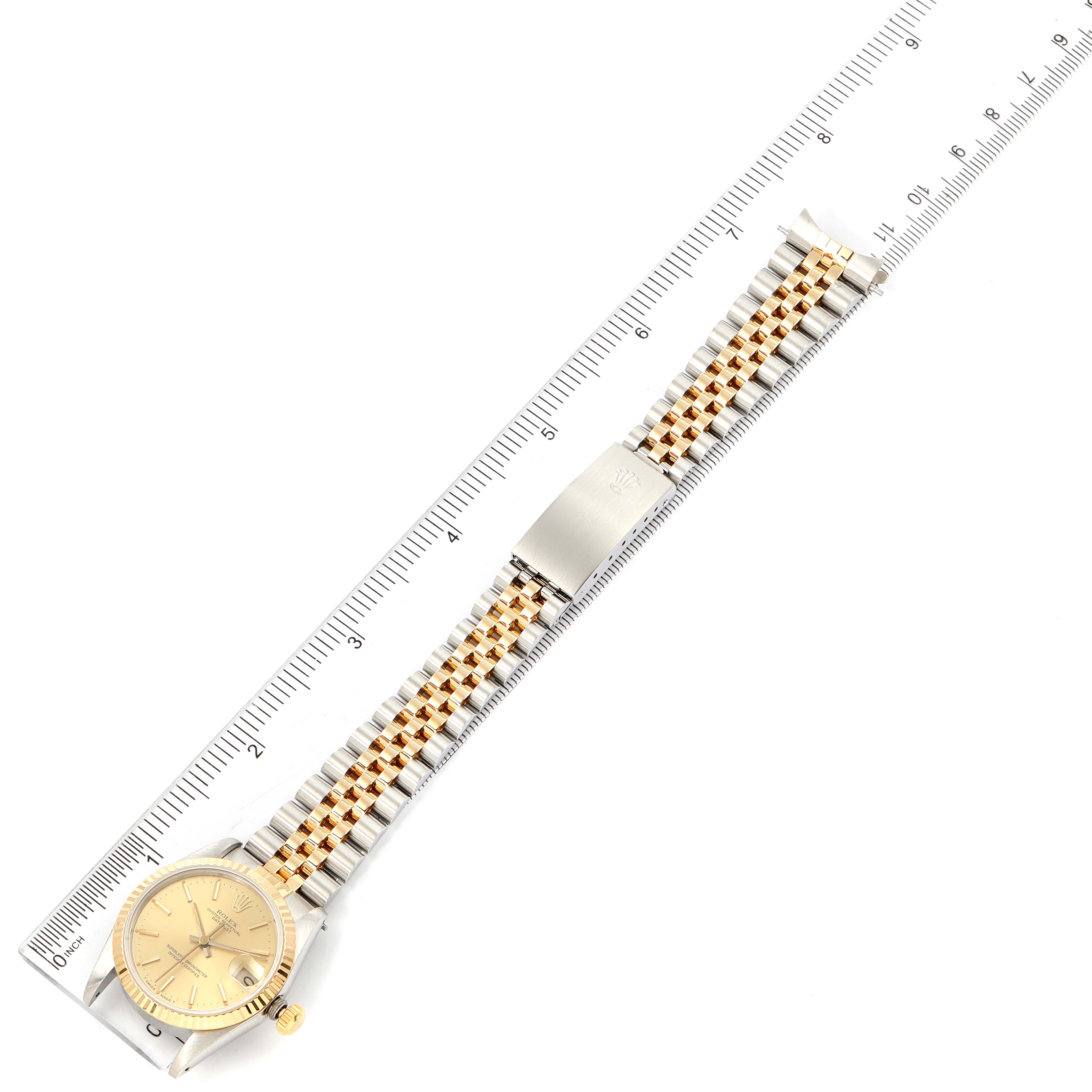 The image shows a top view of a Rolex Mid-Size 68273 Women's Steel and Gold (two tone) Champagne Dial 68273 Women's Steel and Gold (two tone) Champagne Dial watch with a two-tone bracelet and a ruler measuring its length.