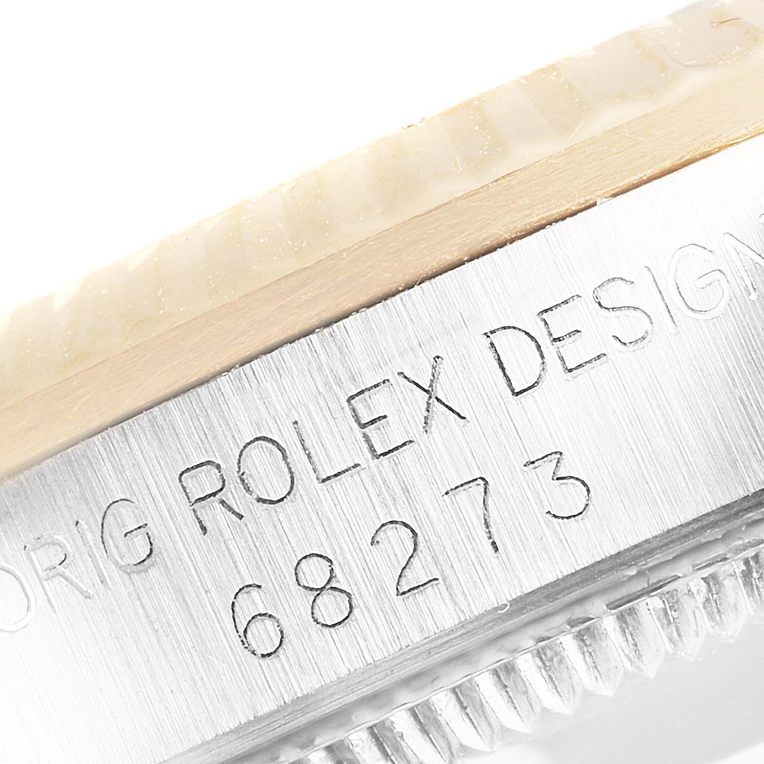 This close-up image shows the model number and inscription on the side of the bezel of a Rolex Mid-Size 68273 Women's Steel and Gold (two tone) Champagne Dial 68273 Women's Steel and Gold (two tone) Champagne Dial 68273 watch.