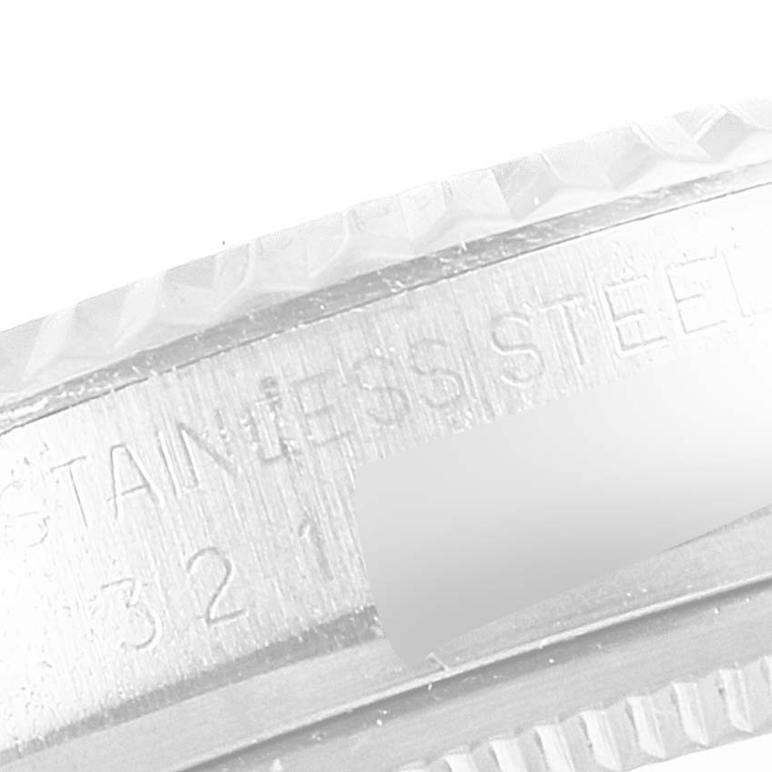 This close-up image shows the stainless steel bezel and part of the case back of a Vintage Collection Rolex watch.