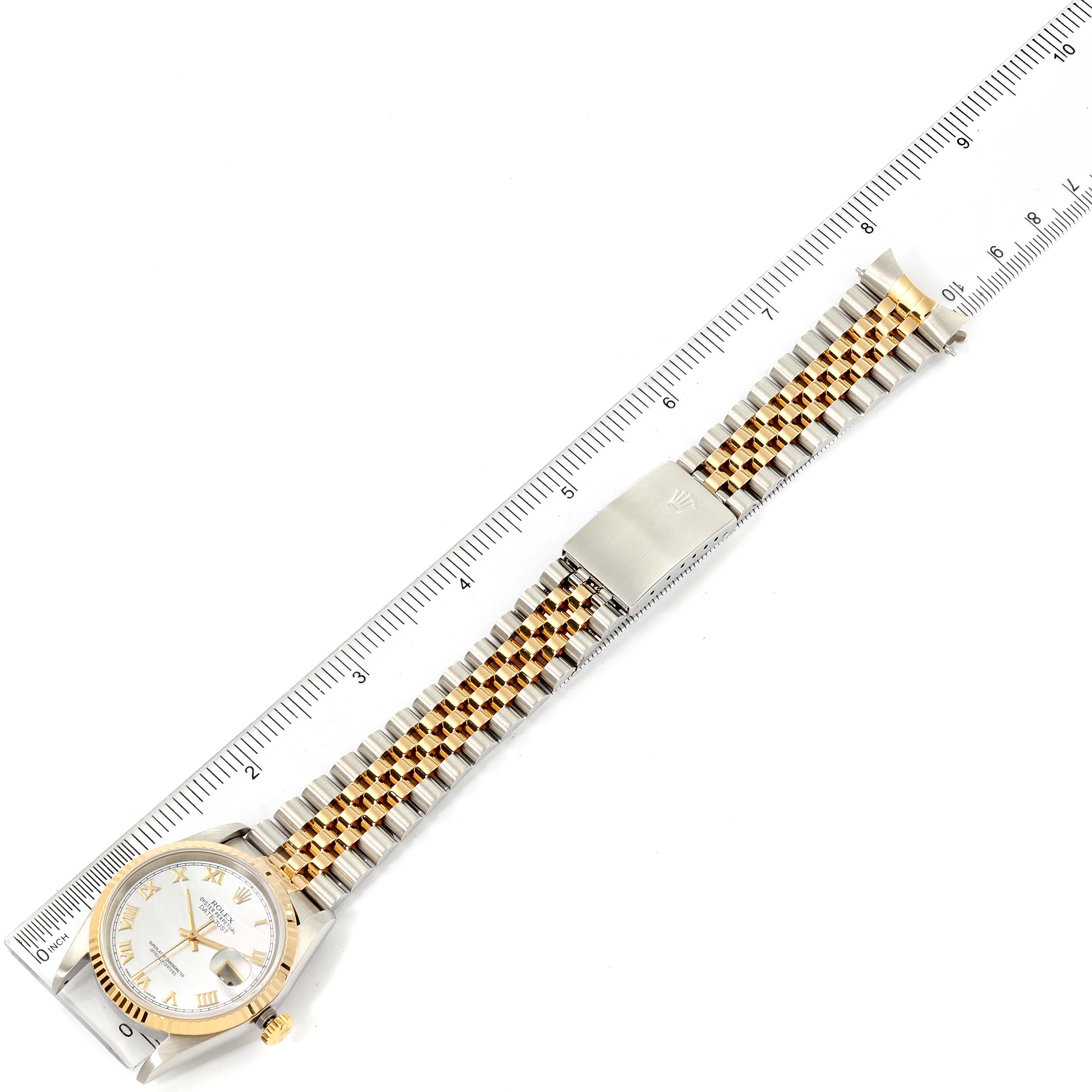 This image shows a top view of a Rolex Datejust 16233 Men's Steel and Gold (two tone) Mother of Pearl Dial 16233 Men's Steel and Gold (two tone) Mother of Pearl Dial watch alongside a ruler, displaying the watch's face and two-tone bracelet.