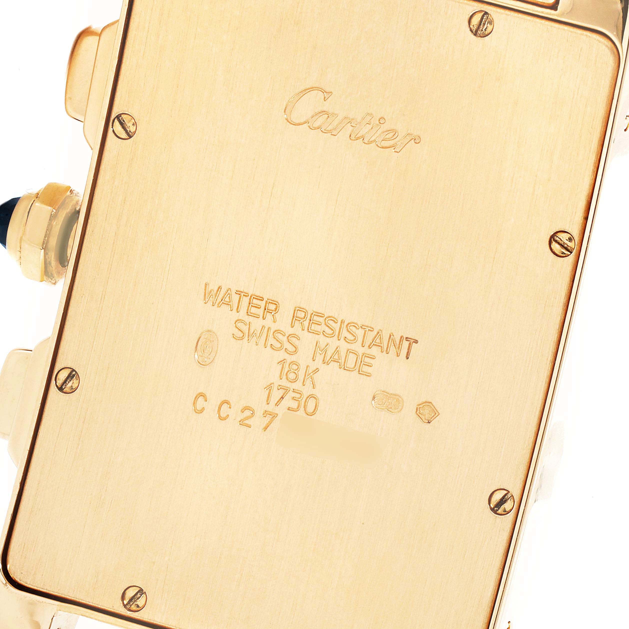 This image shows the back casing, screws, and inscriptions of the Cartier Tank Americaine W2601156 Men's Yellow Gold Silver Dial W2601156 Men's Yellow Gold Silver Dial watch.