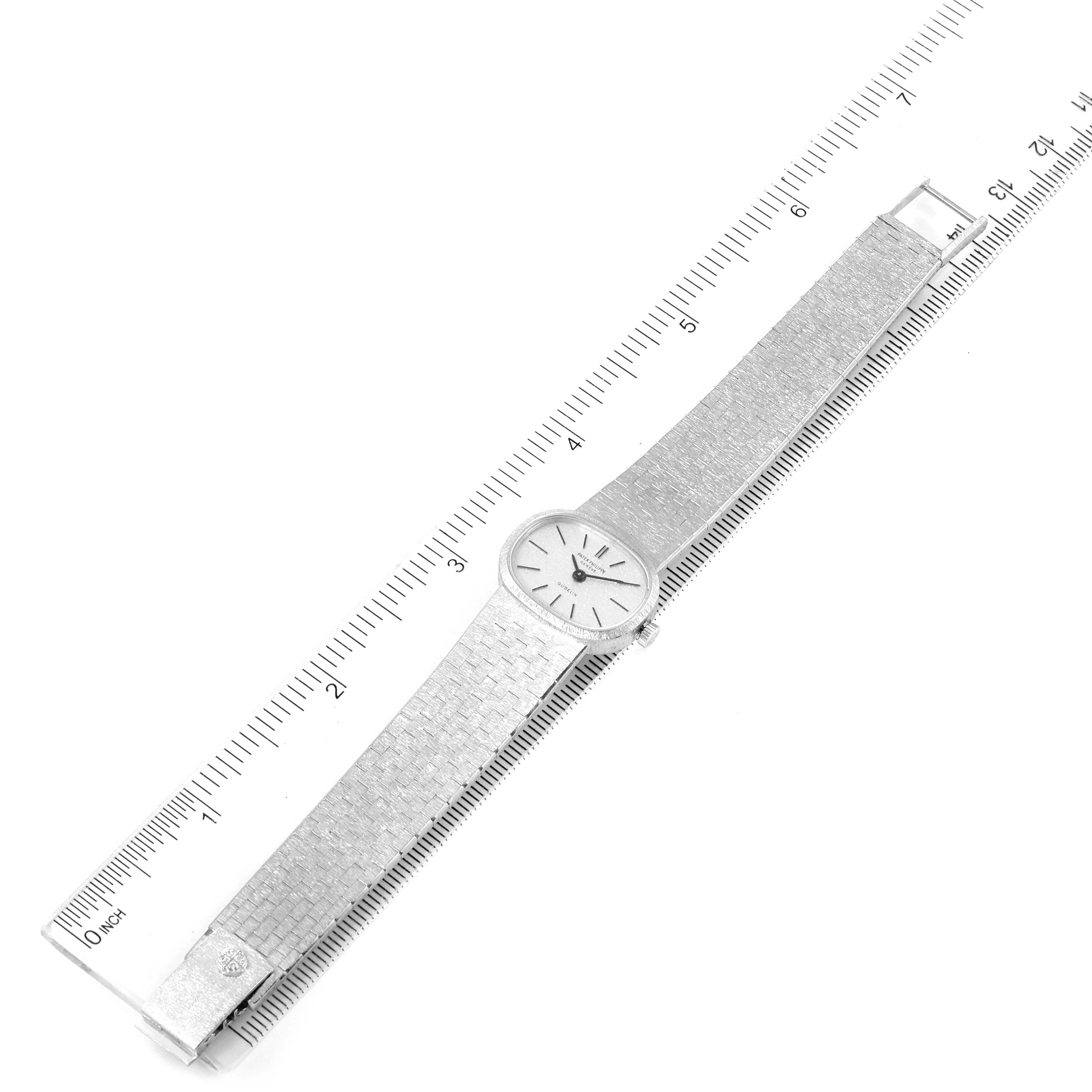 The image shows a top view of a Vintage Patek Philippe watch, including the watch face, band, and clasp next to a ruler.