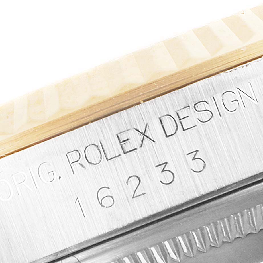 This close-up image shows the model number and part of the bezel of a Rolex Datejust 16233 Men's Steel and Gold (two tone) Mother of Pearl Dial 16233 Men's Steel and Gold (two tone) Mother of Pearl Dial watch.