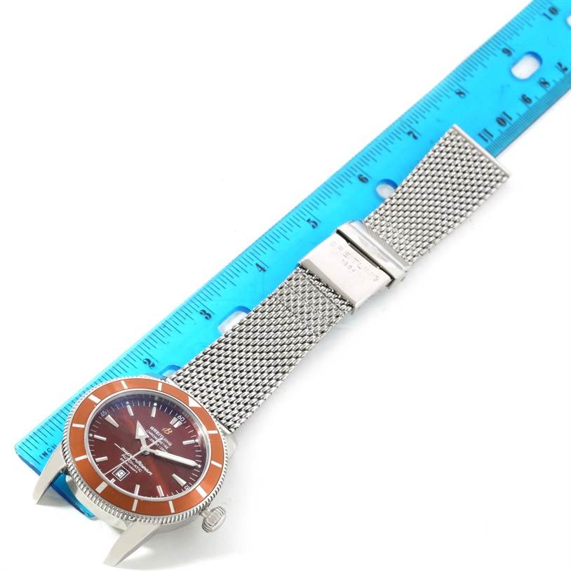 The Breitling Superocean A17320 Men's Stainless Steel Brown Dial A17320 Men's Stainless Steel Brown Dial watch is shown from a top-down angle, highlighting its orange bezel, dial, and mesh bracelet.