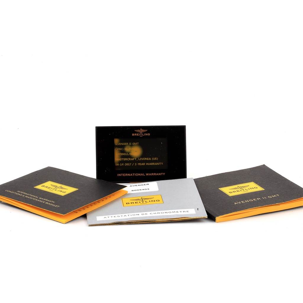 The image shows the Breitling Avenger A32390 Men's Stainless Steel Black Dial A32390 Men's Stainless Steel Black Dial II GMT watch documentation and warranty cards from a front, slightly angled perspective.