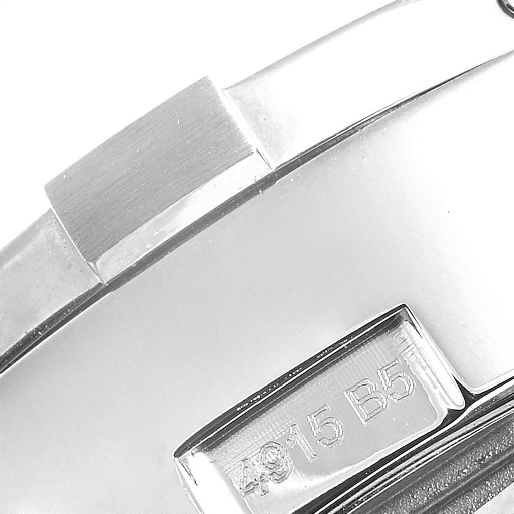 The image shows a close-up of a part of the case of a Breitling Avenger A13381 Men's Stainless Steel Black Dial A13381 Men's Stainless Steel Black Dial watch, featuring some markings and polished metal.