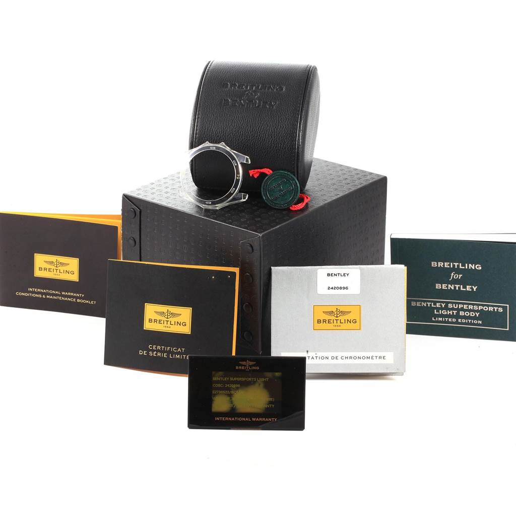 The image shows a Breitling Bentley E27365 Men's Titanium Black Dial E27365 Men's Titanium Black Dial model watch case and accessories, including manuals, certificates, and tags, from a slightly elevated angle.