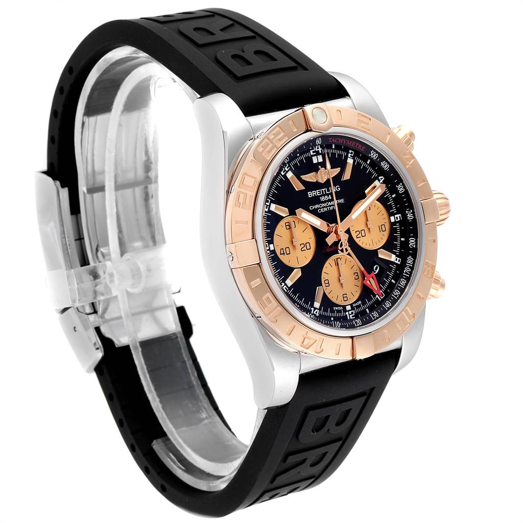 This Breitling Chronomat CB042012/BB86 Men's Steel and Gold (two tone) Black Dial CB042012/BB86 Men's Steel and Gold (two tone) Black Dial watch is shown at a three-quarter angle, featuring its dial, bezel, and black rubber strap.