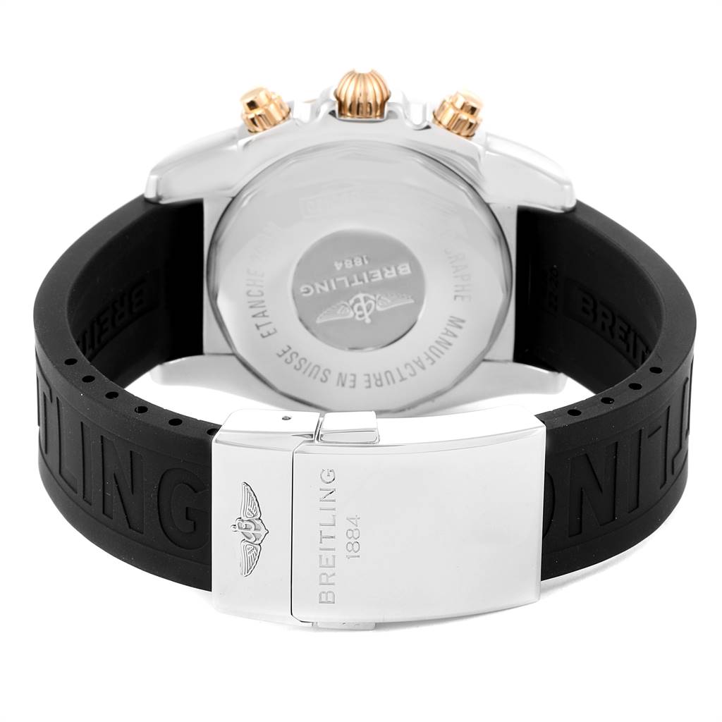 The image shows the back view of a Breitling Chronomat CB042012/BB86 Men's Steel and Gold (two tone) Black Dial CB042012/BB86 Men's Steel and Gold (two tone) Black Dial watch, highlighting its case back and rubber strap with a metal clasp.