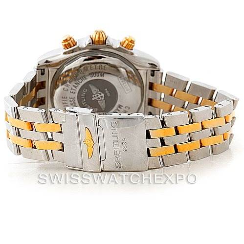 The image shows the back and partially the bracelet of a Breitling Chronomat B13356 Men's Steel and Gold (two tone) Black Dial B13356 Men's Steel and Gold (two tone) Black Dial watch, highlighting its two-tone metal and clasp with the Breitling logo.