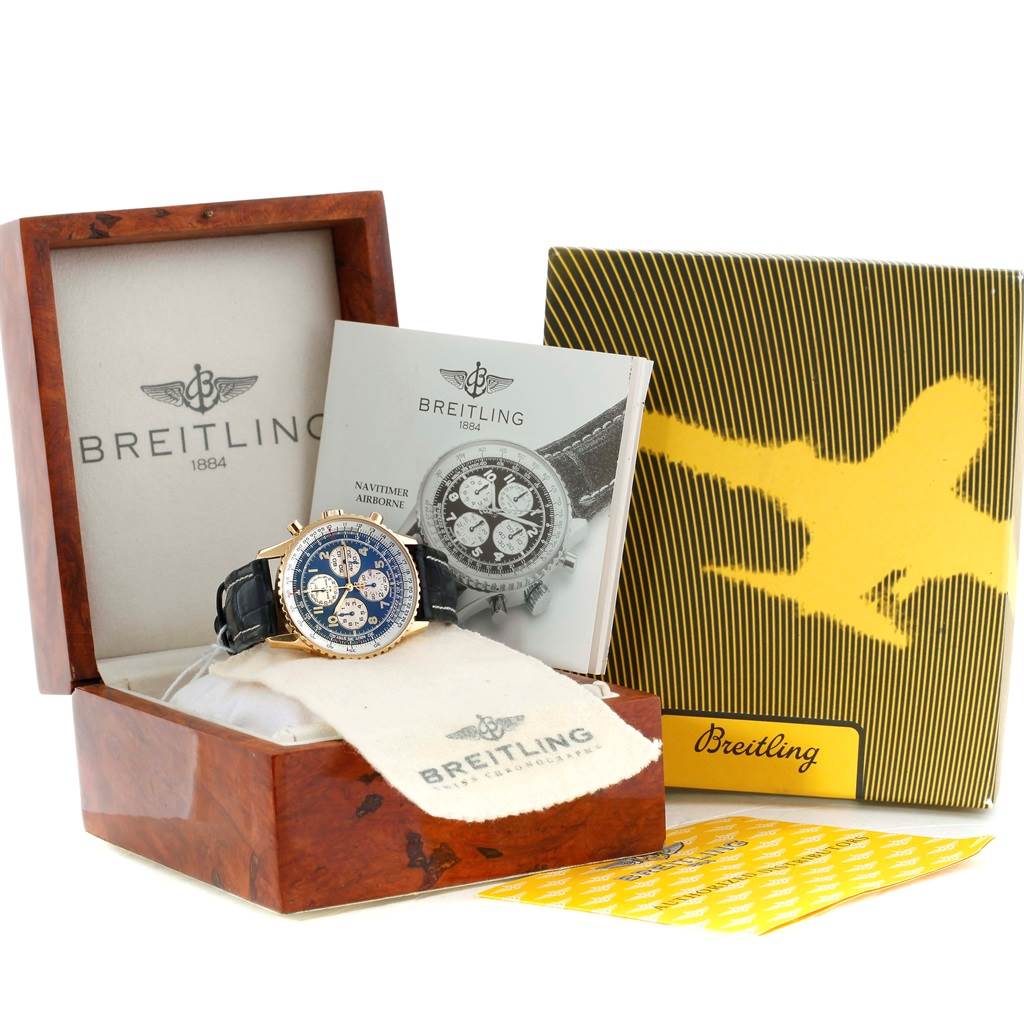 The image shows a Breitling Navitimer K33030 Men's Yellow Gold Blue Dial K33030 Men's Yellow Gold Blue Dial watch in its wooden box, with accompanying booklets and a cleaning cloth.