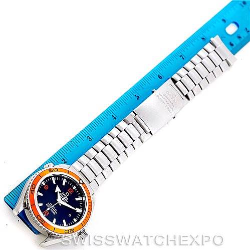 The image shows a full view of the Omega Planet Ocean 2208.50.00 Men's Stainless Steel Black Dial 2208.50.00 Men's Stainless Steel Black Dial watch, with its orange bezel and stainless steel bracelet, placed next to a blue ruler for scale.