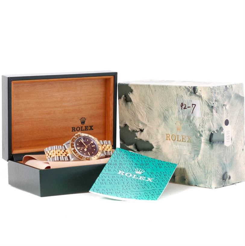 The Rolex Vintage Collection 1675 Men's Stainless Steel Brown Dial 1675 Men's Stainless Steel Brown Dial watch is shown at an angle displaying its case, bracelet, and dial, along with its box and papers.