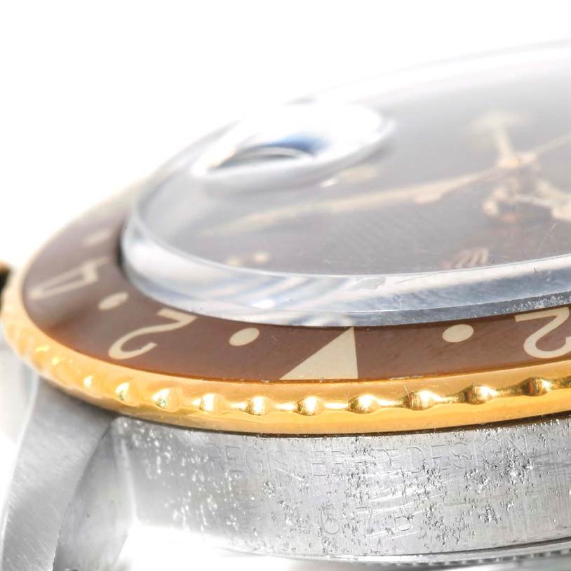 The image shows a close-up side angle of the bezel, crystal, and part of the case of a Rolex Vintage Collection 1675 Men's Stainless Steel Brown Dial 1675 Men's Stainless Steel Brown Dial watch.