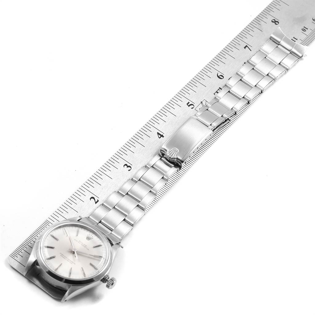 The image shows a Rolex Vintage Collection 1002 Men's Stainless Steel Silver Dial 1002 Men's Stainless Steel Silver Dial model watch laid flat, aligned with a ruler, highlighting its clasp and stainless steel bracelet.