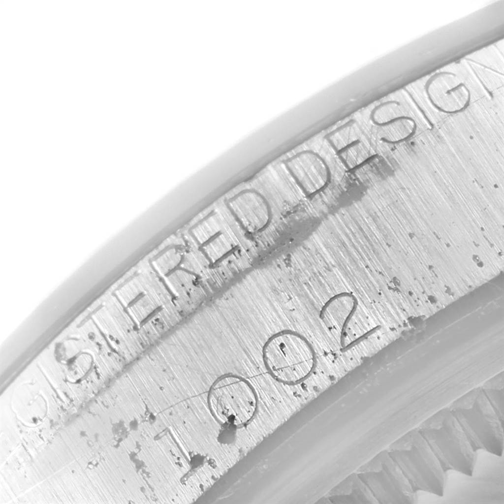 This image shows a close-up angle of the engraved text and numbers on the side of a Rolex Vintage Collection 1002 Men's Stainless Steel Silver Dial 1002 Men's Stainless Steel Silver Dial watch case.
