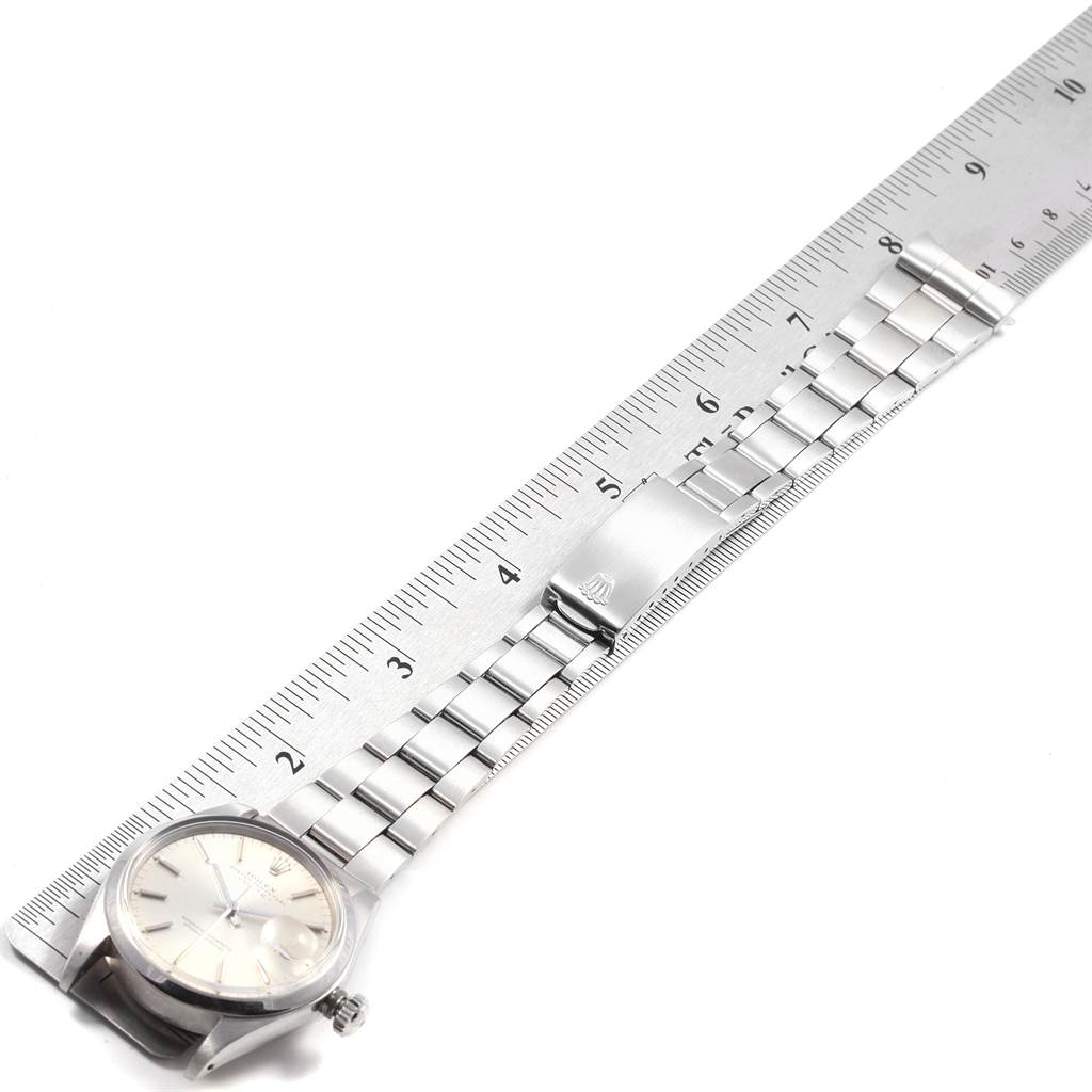 The image shows the Rolex Vintage Collection 1500 Men's Stainless Steel Silver Dial 1500 Men's Stainless Steel Silver Dial watch from an overhead angle, highlighting its face, bracelet, and clasp alongside a ruler.