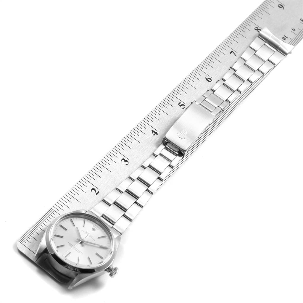 The Rolex Vintage Collection 1002 Men's Stainless Steel Silver Dial 1002 Men's Stainless Steel Silver Dial watch is shown flat with a silver metal strap and a clasp beside a ruler for measurement.
