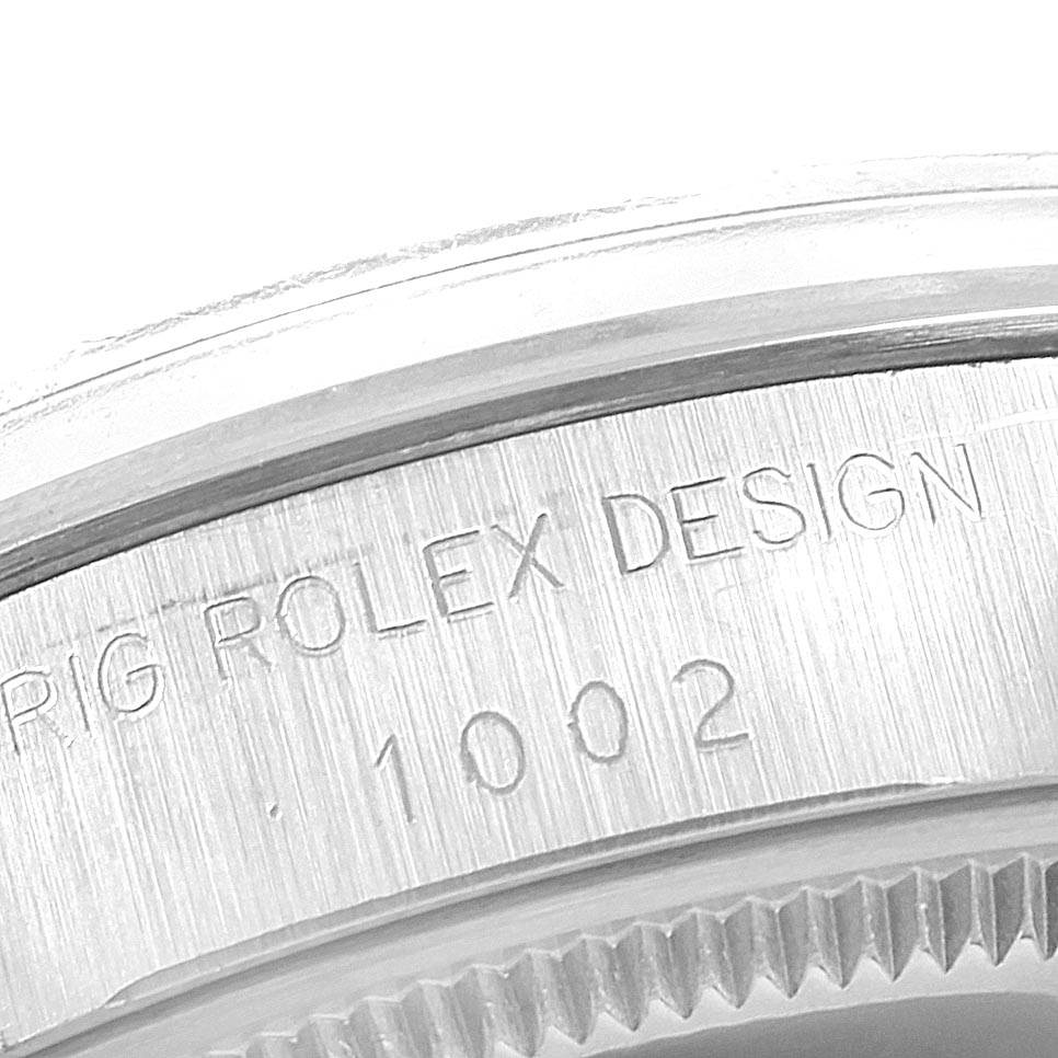 The image shows a close-up view of the engraved bezel on a Rolex Vintage Collection 1002 Men's Stainless Steel Silver Dial 1002 Men's Stainless Steel Silver Dial model.