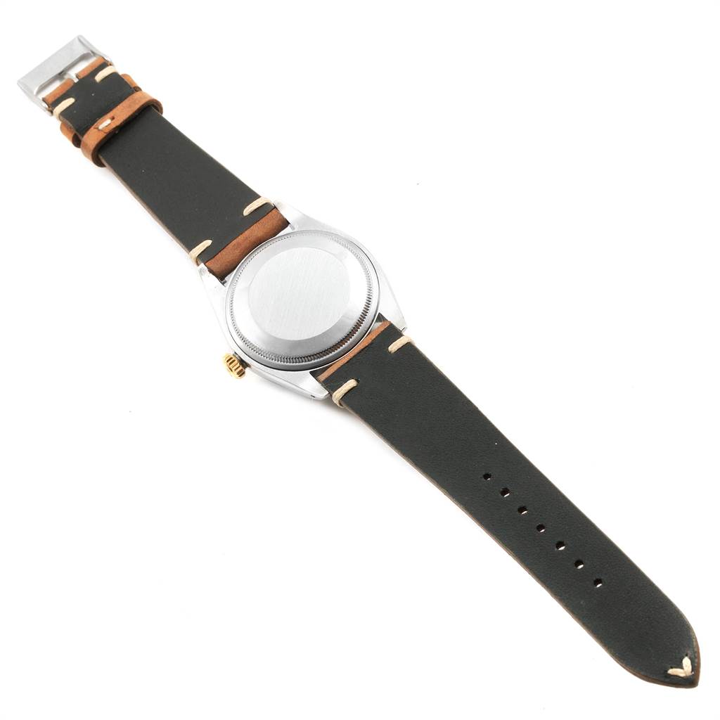 The image shows the back view of a Rolex Vintage Collection 1500 Men's Stainless Steel Silver Dial 1500 Men's Stainless Steel Silver Dial watch, highlighting its case back, leather strap, and buckle.