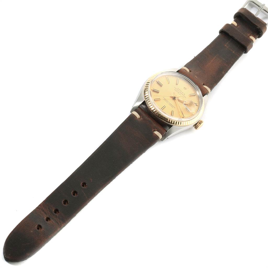 The Rolex Vintage Collection 16013 Men's Stainless Steel Champagne Dial 16013 Men's Stainless Steel Champagne Dial watch is shown at an oblique angle, displaying its face, case, crown, and brown leather strap.