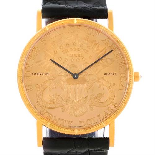 Front view of a Corum Coin Watch Men's Yellow Gold Black Dial Men's Yellow Gold Black Dial model, showing its gold face with an engraved design and black leather band.