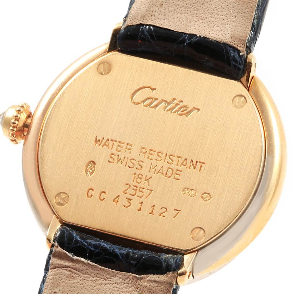 This image shows the back of a Trinity model watch by Cartier, highlighting its inscriptions and leather strap attachments.