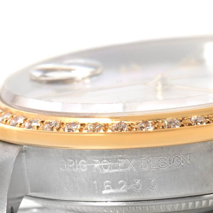 The image shows a close-up of the Rolex Datejust 16233 Men's Steel and Gold (two tone) Mother of Pearl Dial 16233 Men's Steel and Gold (two tone) Mother of Pearl Dial model's side, featuring its diamond bezel and part of the watch case with markings.
