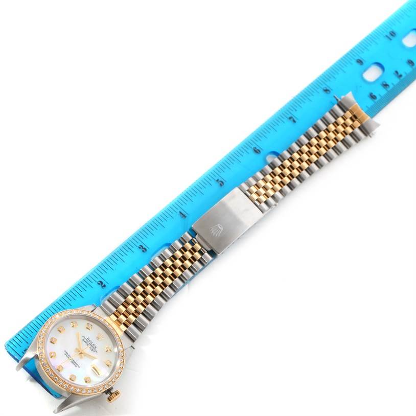 The Rolex Datejust 16233 Men's Steel and Gold (two tone) Mother of Pearl Dial 16233 Men's Steel and Gold (two tone) Mother of Pearl Dial watch is shown laid flat with its bracelet stretched out next to a ruler for measurement.