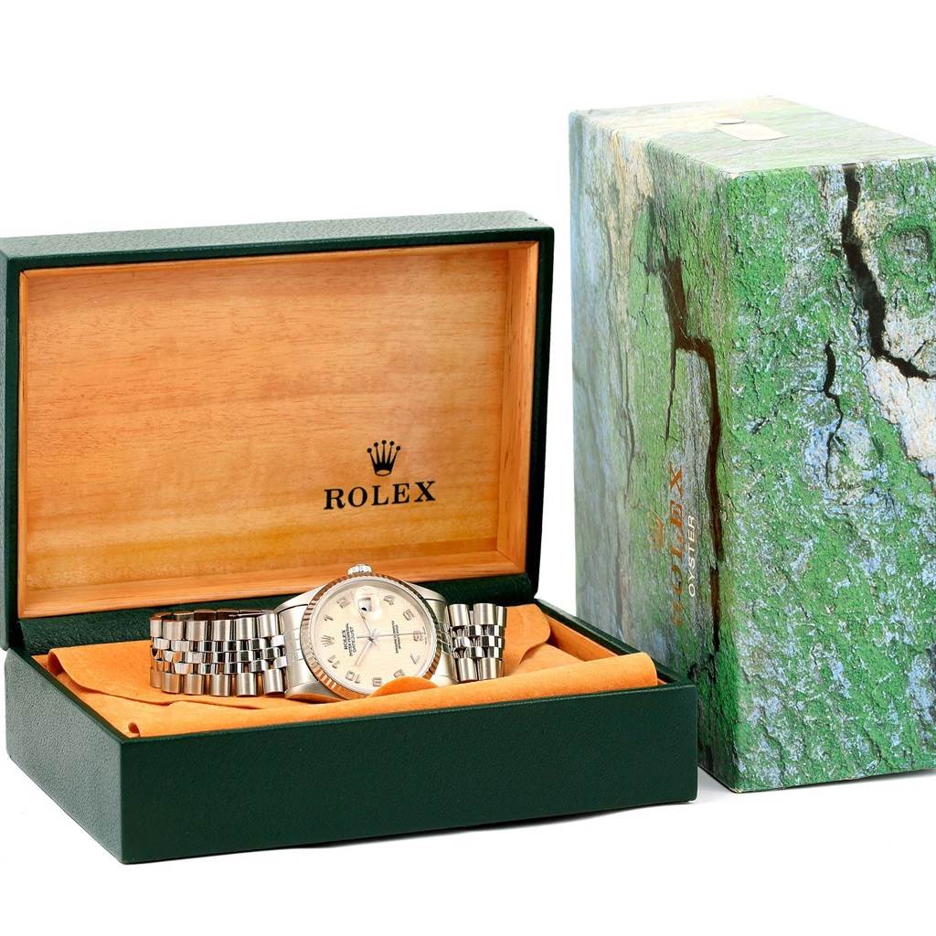 The Rolex Datejust 16234 Men's Stainless Steel Beige Dial 16234 Men's Stainless Steel Beige Dial watch is shown in its open box, revealing the dial and part of the bracelet, along with the outer packaging.
