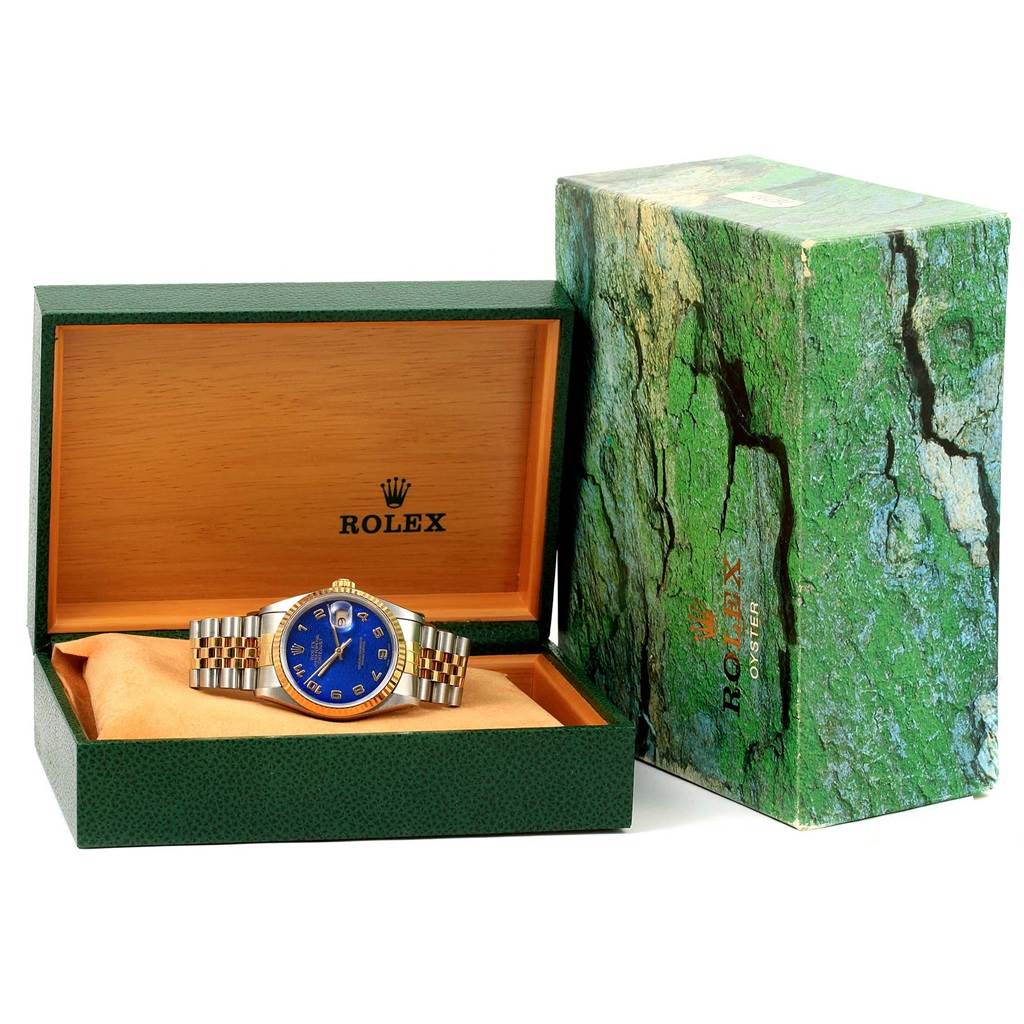 The Rolex Datejust 16233 Men's Steel and Gold (two tone) Blue Dial 16233 Men's Steel and Gold (two tone) Blue Dial watch is shown in its open box with its outer box beside it, displaying the dial and bracelet.