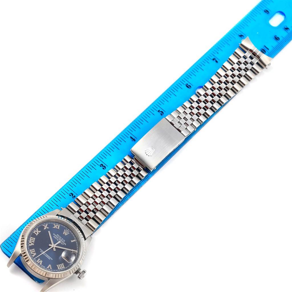 The image shows a Rolex Datejust 16234 Men's Stainless Steel Blue Dial 16234 Men's Stainless Steel Blue Dial watch laid flat with its bracelet extended, against a blue ruler for measurement.