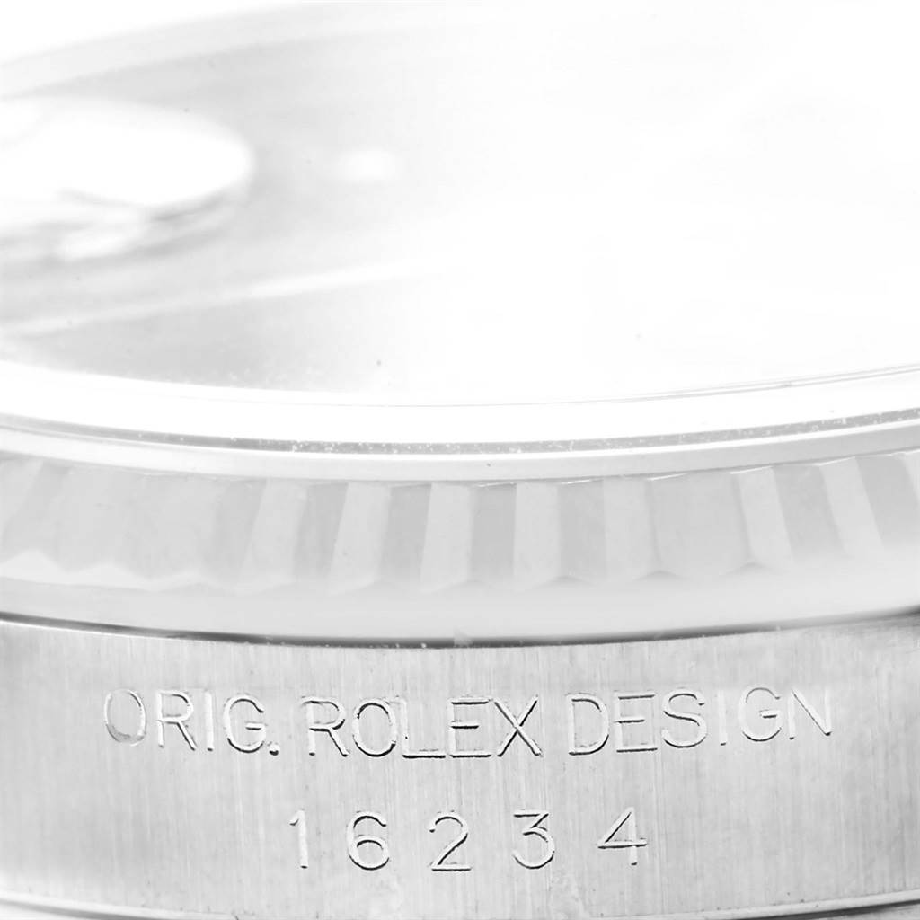 This image shows a close-up of the Rolex Datejust 16234 Men's Stainless Steel Blue Dial 16234 Men's Stainless Steel Blue Dial bezel and engraved case side.