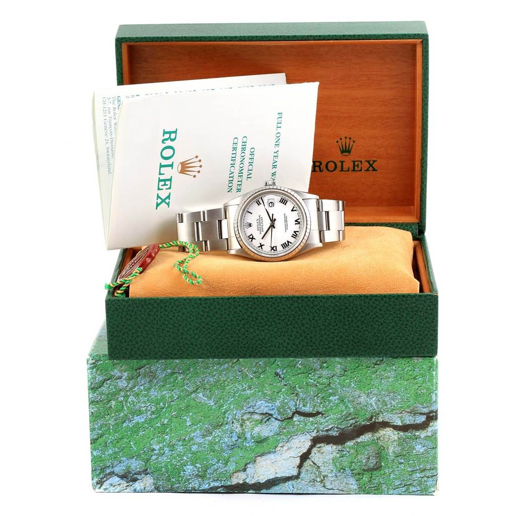 The Rolex Datejust 16220 Men's Stainless Steel White Dial 16220 Men's Stainless Steel White Dial watch is displayed front and center inside an open green box, with documentation alongside it.