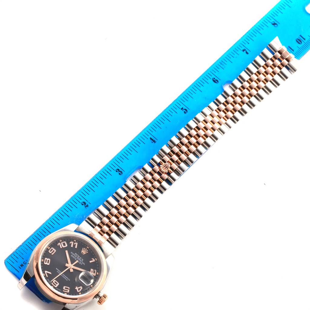 The image shows a top-down view of a Rolex Datejust 116201 Men's Steel and Gold (two tone) Black Dial 116201 Men's Steel and Gold (two tone) Black Dial watch with the face, bezel, and bracelet positioned next to a ruler.
