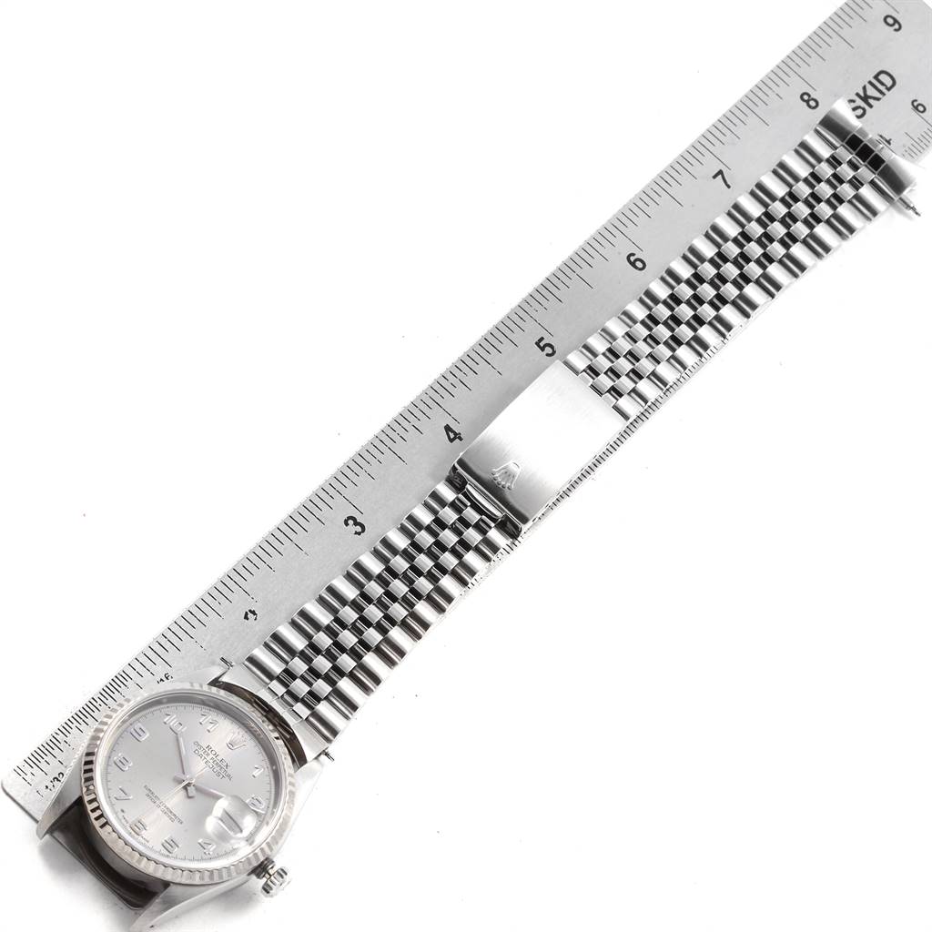 This image shows the Rolex Datejust 16234 Men's Stainless Steel Silver Dial 16234 Men's Stainless Steel Silver Dial watch and its stainless steel bracelet laid flat next to a ruler for size reference.