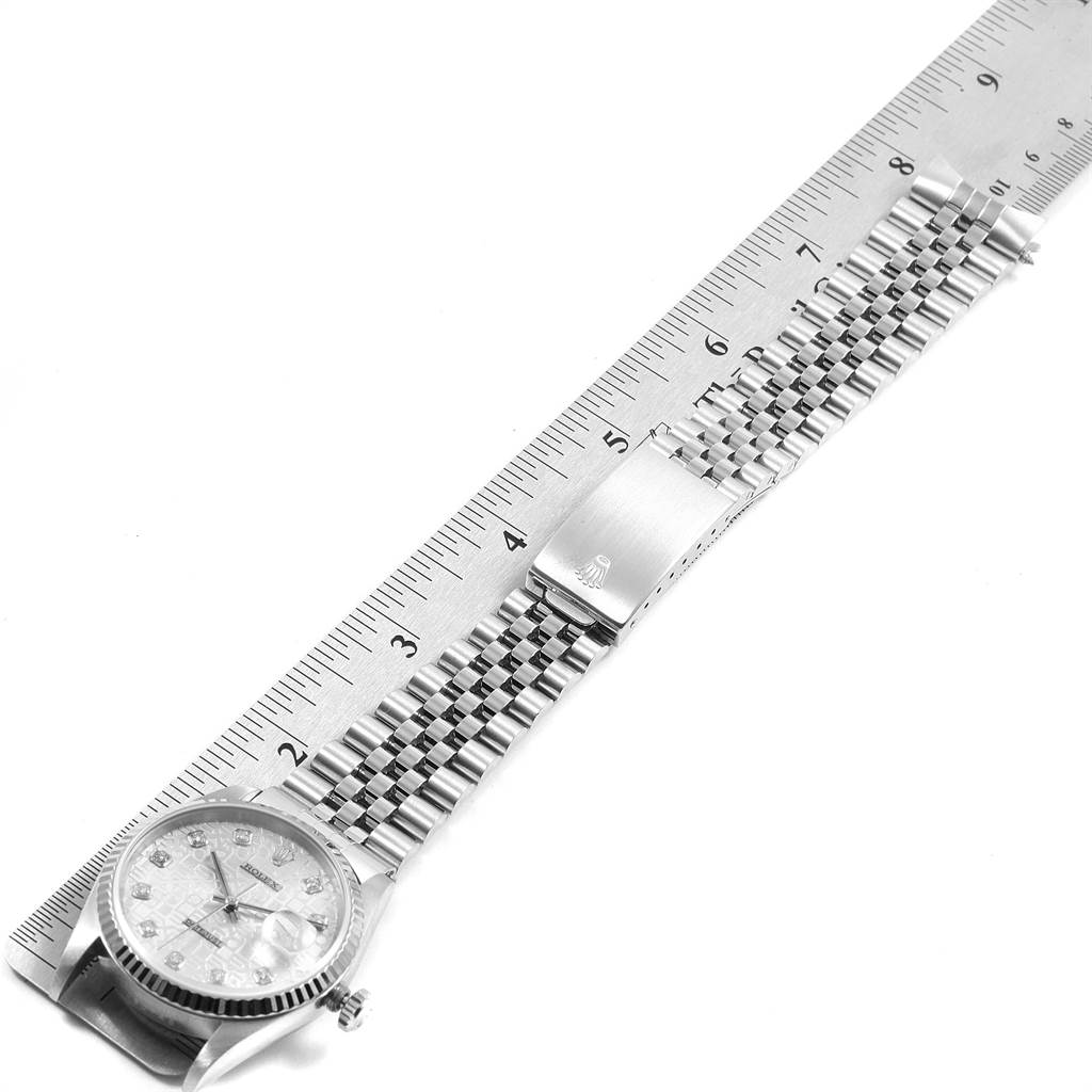 The image shows a Rolex Datejust 16234 Men's Stainless Steel Silver Dial 16234 Men's Stainless Steel Silver Dial watch from an elevated angle, detailing the face and metal bracelet next to a ruler.