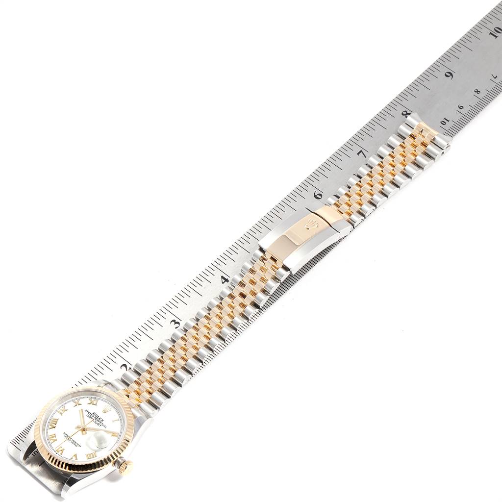 The Rolex Datejust 126233 Men's Steel and Gold (two tone) White Dial 126233 Men's Steel and Gold (two tone) White Dial watch is shown from the top, highlighting the face, bezel, and Jubilee bracelet against a ruler.