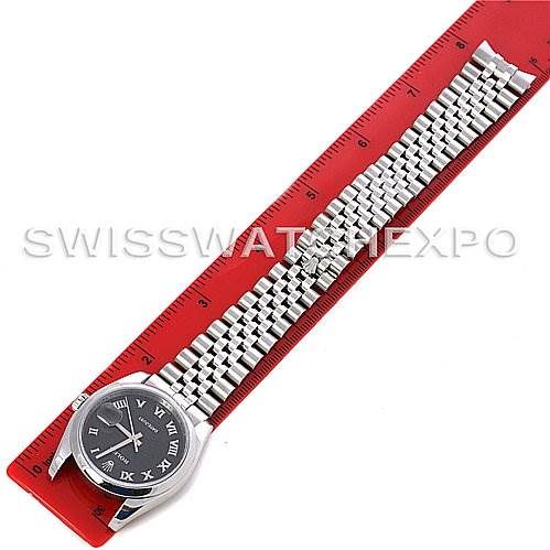 This image shows a top view of a Rolex Datejust 116200-BKRJ Men's Stainless Steel Black Dial 116200-BKRJ Men's Stainless Steel Black Dial watch placed on a red ruler, displaying the face and full metal bracelet.