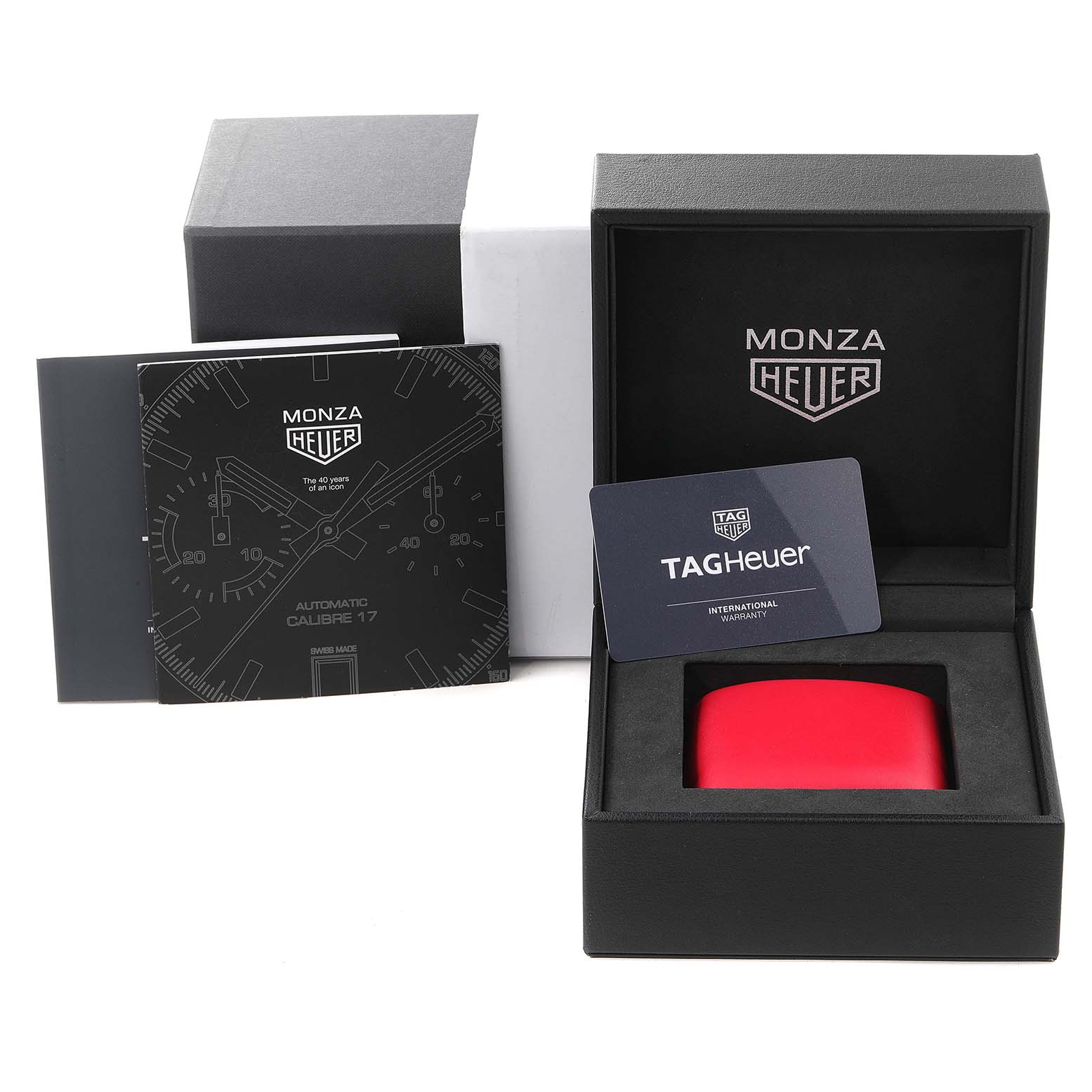 The image shows the packaging, manual, warranty card, and box for the Tag Heuer Monza watch model.