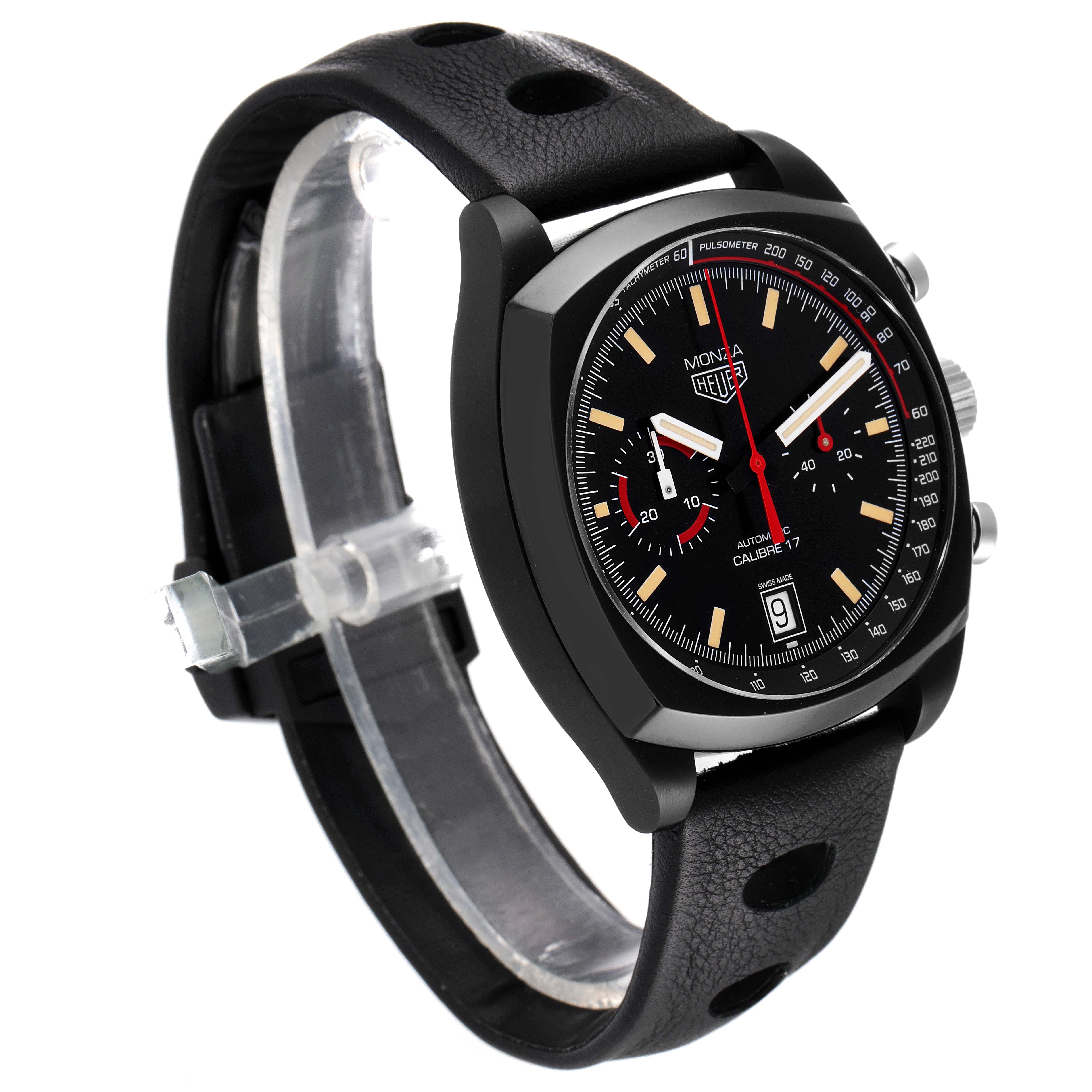 The image shows a Tag Heuer Monza watch from a slight side angle, highlighting the black dial, chronograph subdials, and perforated black leather strap.