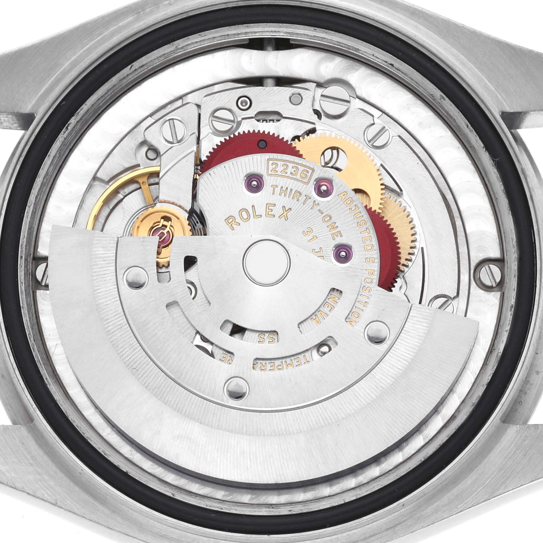 The image shows the movement of a Rolex Datejust watch from a back view, highlighting gears and the rotor.