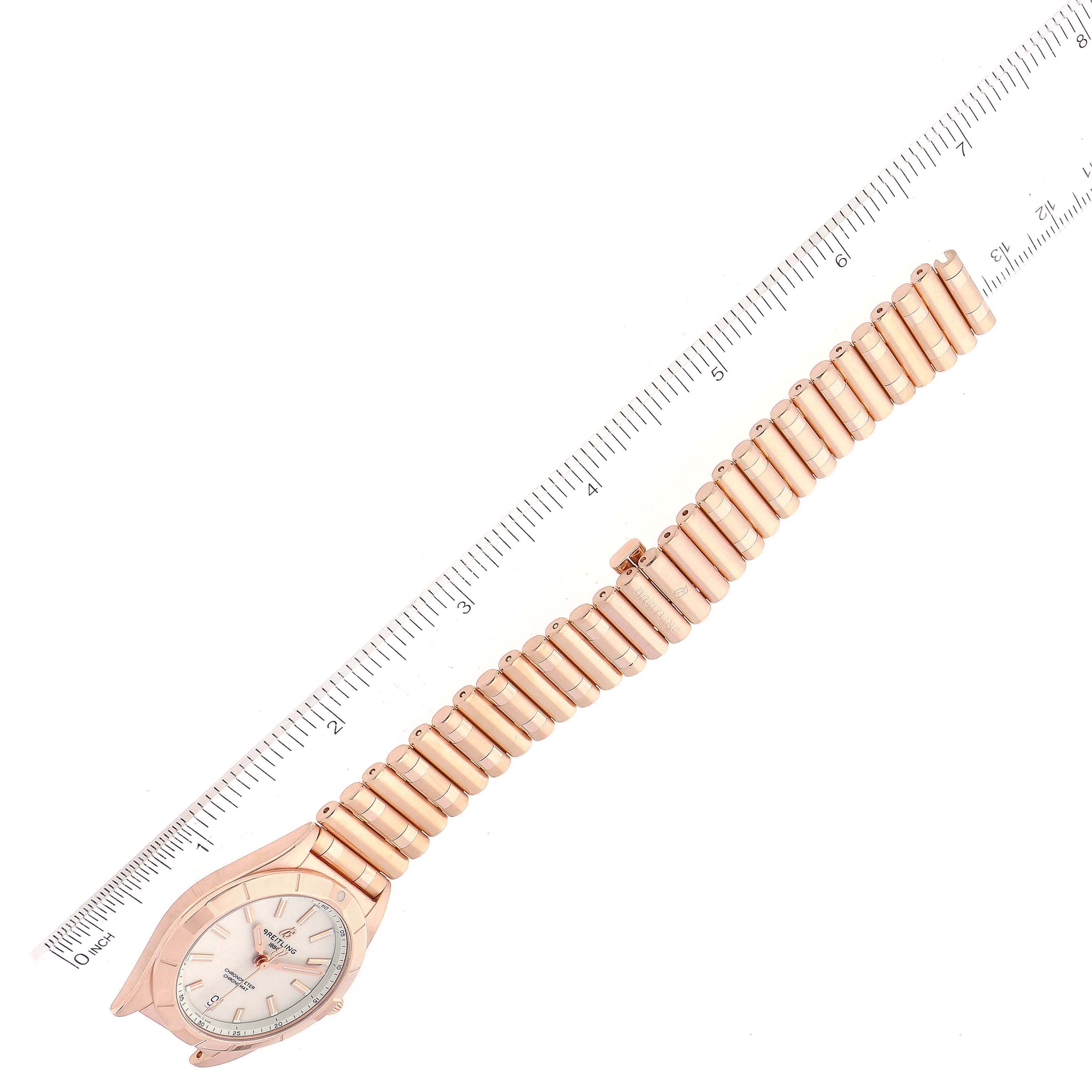 The Breitling R77310101A1R1 Women's Rose Gold White Dial R77310101A1R1 Women's Rose Gold White Dial Chronomat 32 White Dial Rose Gold Ladies Watch R77310 is shown at a top-down angle with a ruler for scale.