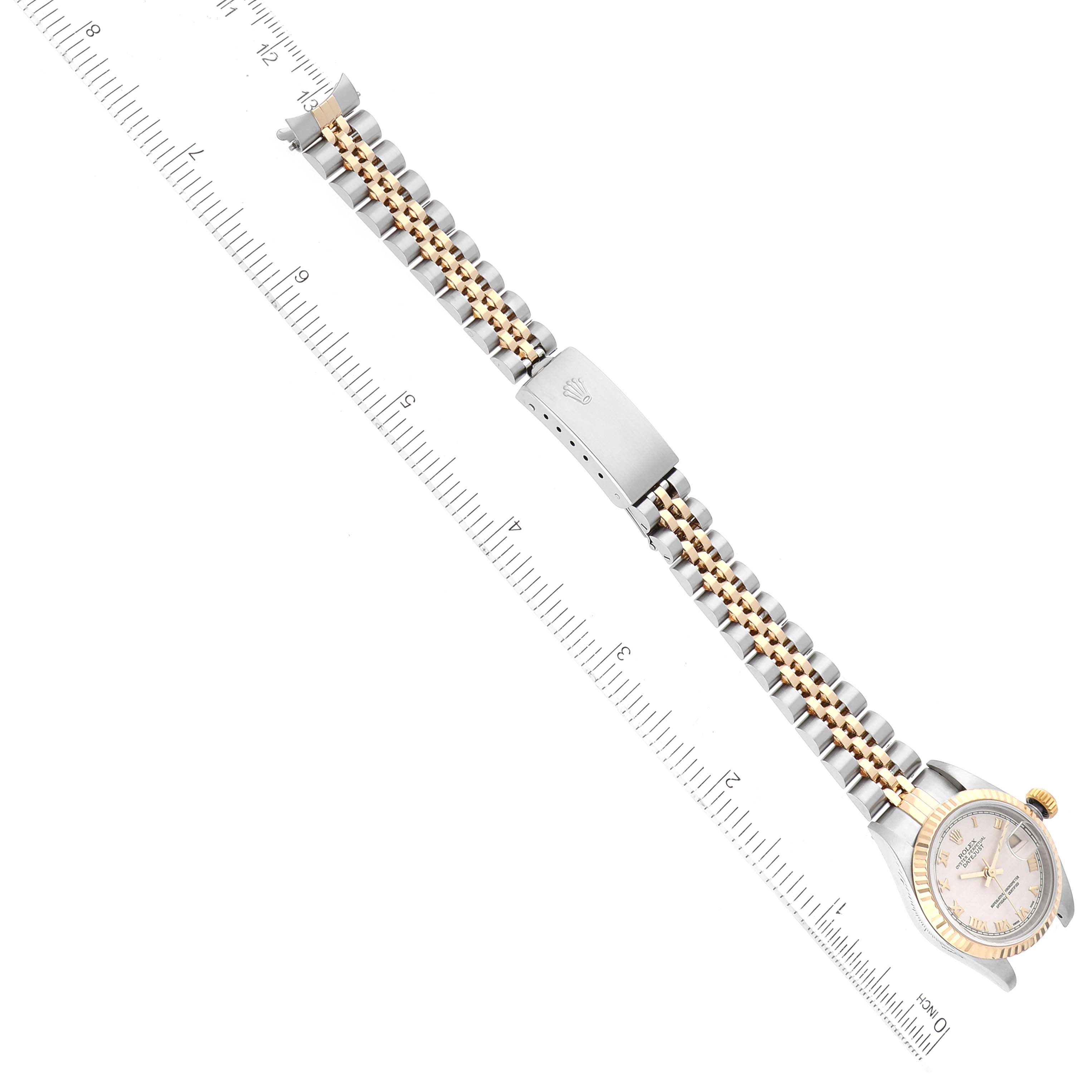 This image shows the Rolex Datejust 79173 Women's Steel and Gold (two tone) Beige Dial 79173 Women's Steel and Gold (two tone) Beige Dial watch laid flat from an overhead angle with a ruler beside it for size reference.