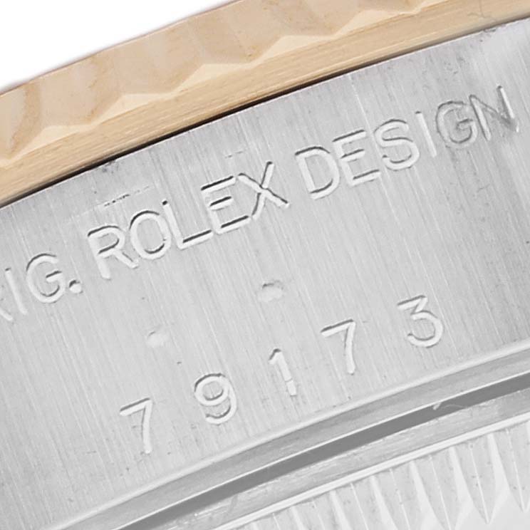 This close-up image shows the side engraving and fluted bezel of a Rolex Datejust 79173 Women's Steel and Gold (two tone) Beige Dial 79173 Women's Steel and Gold (two tone) Beige Dial watch.